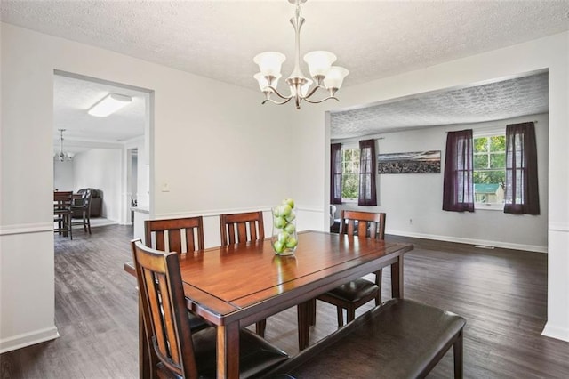 dining room with a textured ceiling, a chandelier, and dark hardwood / wood-style floors