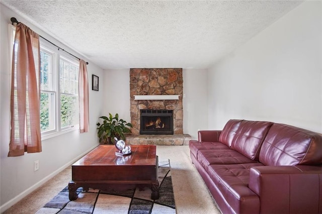 carpeted living room featuring a fireplace, a textured ceiling, and plenty of natural light