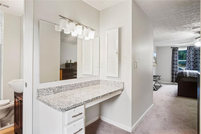 bathroom featuring a textured ceiling, vanity, ceiling fan, and toilet