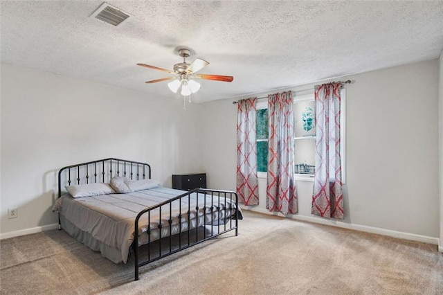 bedroom with a textured ceiling, ceiling fan, and carpet floors