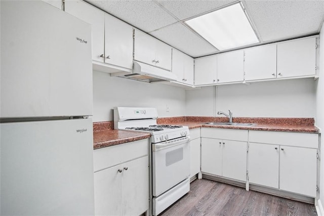 kitchen with white appliances, light hardwood / wood-style floors, white cabinetry, sink, and a paneled ceiling