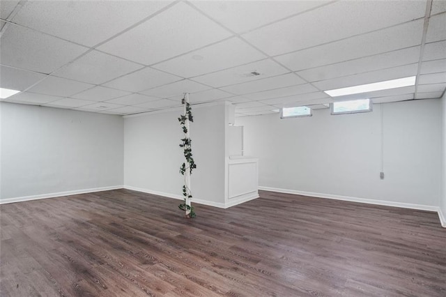 basement with a paneled ceiling and dark wood-type flooring