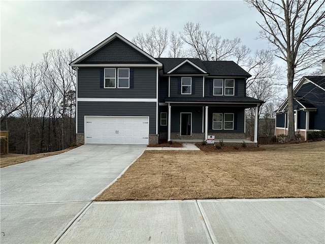 view of front of home with an attached garage, concrete driveway, a porch, and a front yard