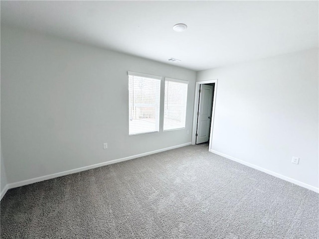 empty room with baseboards, carpet, and visible vents
