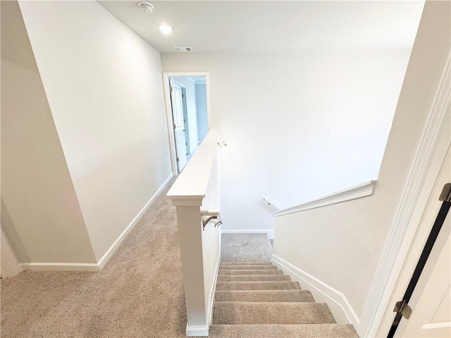 stairway featuring carpet floors, baseboards, and visible vents