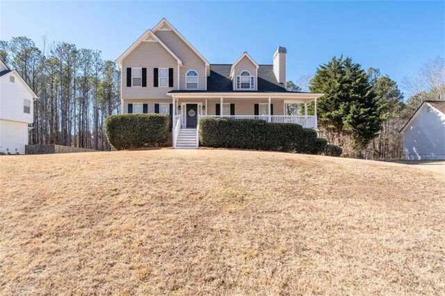 view of front facade with a front yard and covered porch