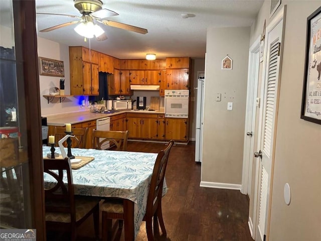 kitchen with dark hardwood / wood-style flooring, sink, white appliances, and ceiling fan