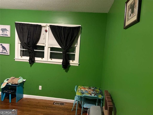 rec room featuring hardwood / wood-style floors and a textured ceiling