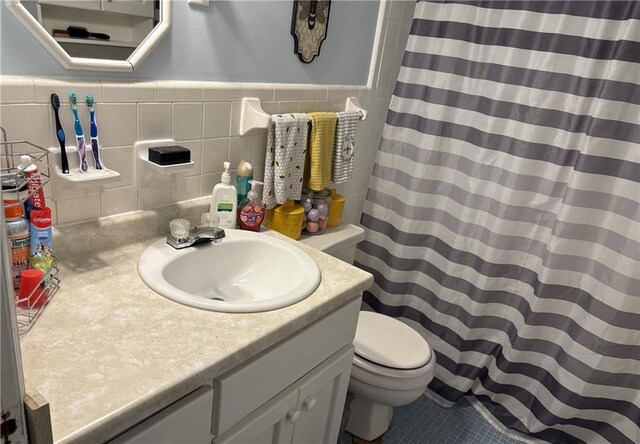 bathroom featuring tile walls, a shower with shower curtain, vanity, tile patterned floors, and toilet