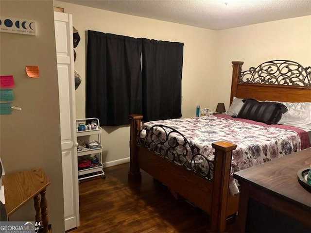 bedroom featuring dark hardwood / wood-style flooring and a textured ceiling