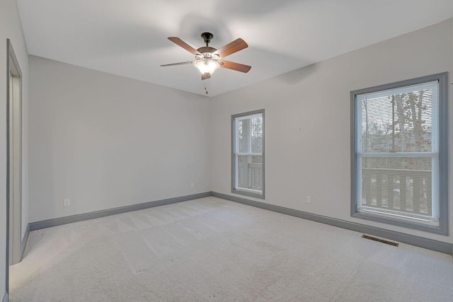 carpeted spare room with ceiling fan