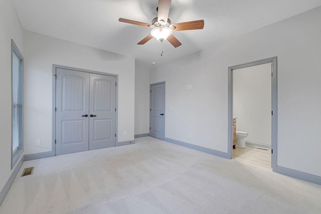 unfurnished bedroom with connected bathroom, ceiling fan, and light carpet