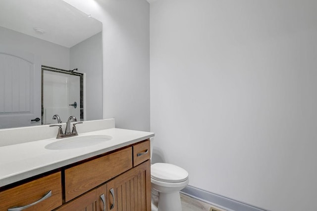 bathroom with vanity, toilet, and an enclosed shower