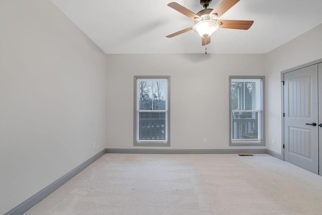 carpeted spare room featuring ceiling fan