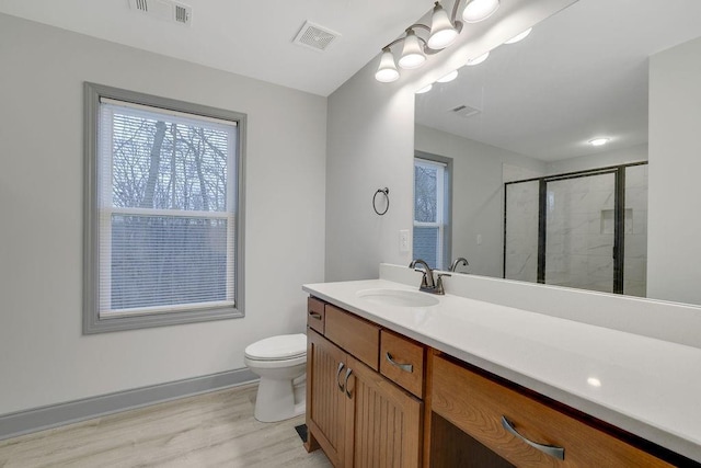 bathroom with a shower with door, vanity, and toilet