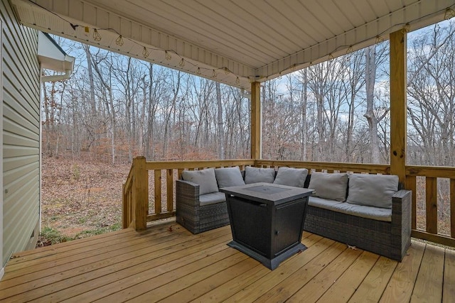 deck with an outdoor living space with a fire pit