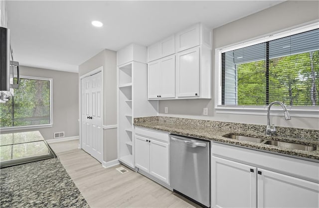 1819 Laurel Ridge Dr SW, Conyers, GA 30094 - kitchen with stainless steel dishwasher, a sink, white cabinets, dark stone countertops, and light wood finished floors