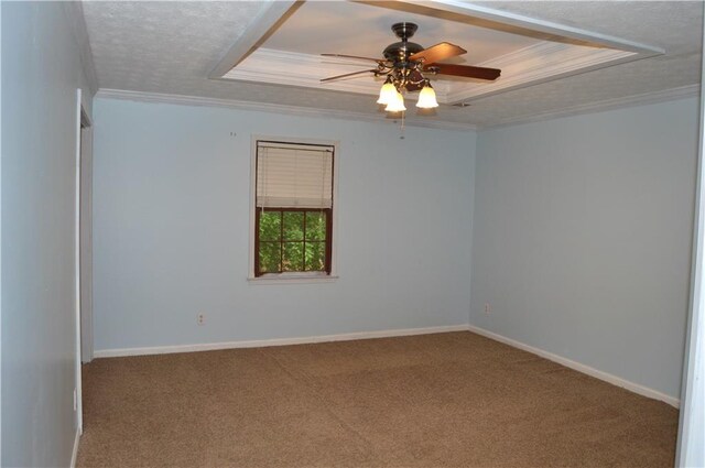 carpeted empty room featuring ceiling fan, baseboards, a tray ceiling, and ornamental molding