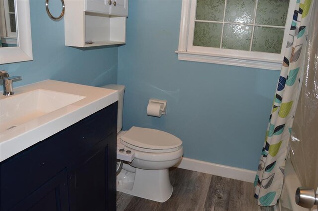 full bathroom featuring toilet, baseboards, wood finished floors, curtained shower, and vanity
