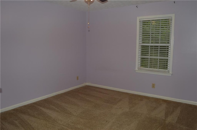 spare room with a ceiling fan, baseboards, and carpet floors