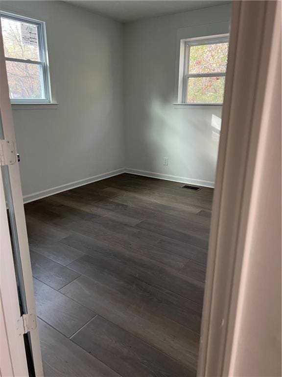 empty room with dark wood-type flooring