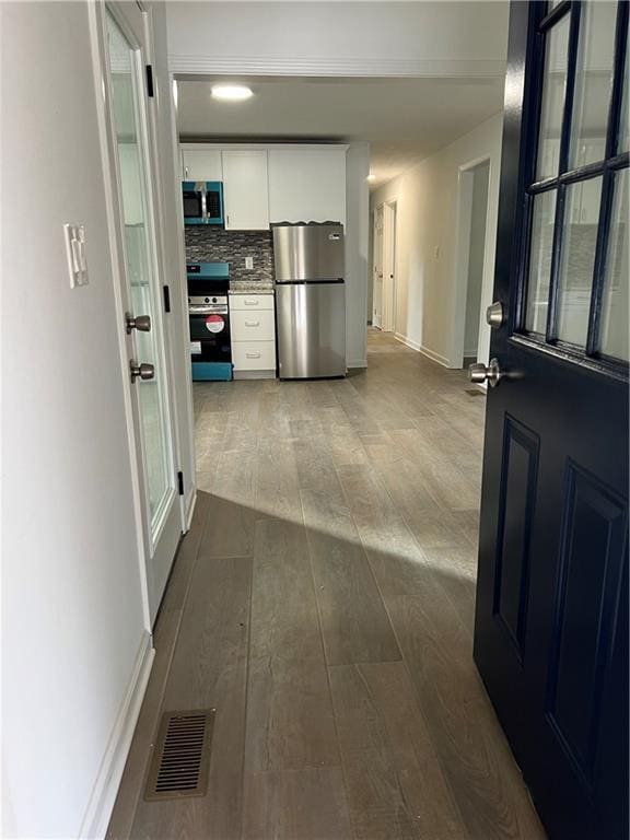 hallway with hardwood / wood-style floors