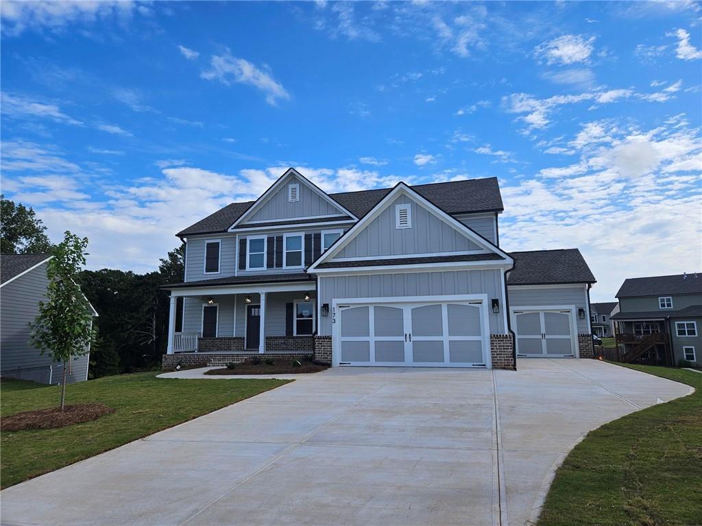 craftsman-style home featuring a porch, a garage, and a front lawn