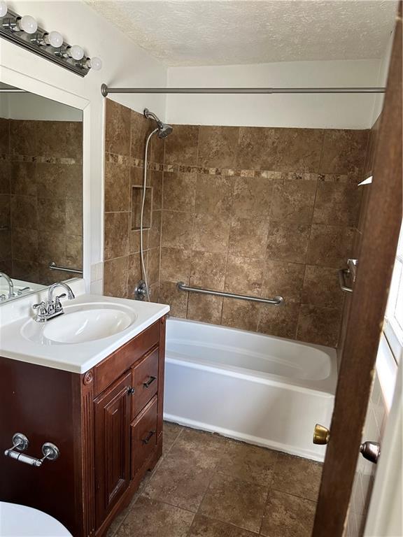2195 Wilson Rd, Conyers, GA 30012 - full bathroom with vanity, shower / tub combination, a textured ceiling, and tile patterned floors