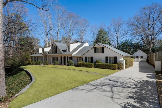 cape cod home featuring a front lawn