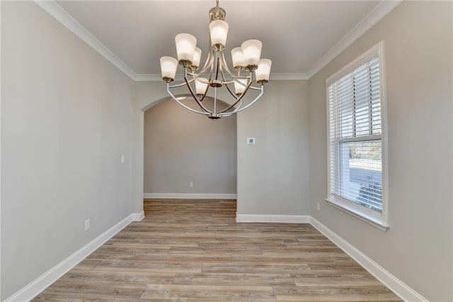 empty room with ornamental molding, light hardwood / wood-style floors, and a notable chandelier