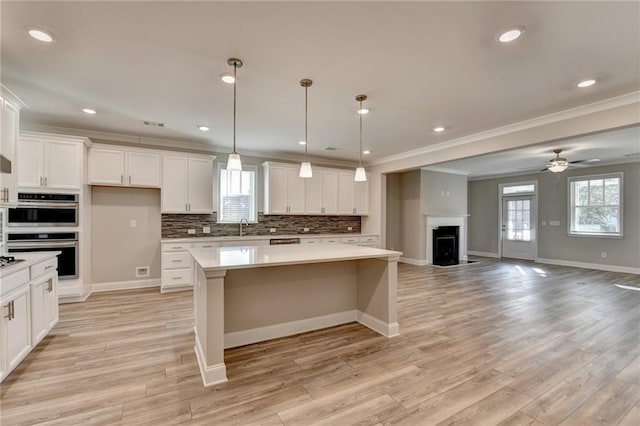 kitchen featuring tasteful backsplash, a kitchen island, pendant lighting, and double oven