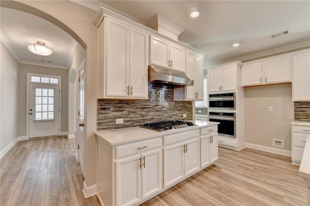 kitchen with white cabinetry, stainless steel appliances, and crown molding