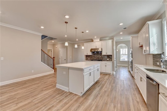 kitchen featuring white cabinetry, stainless steel dishwasher, decorative light fixtures, and a kitchen island