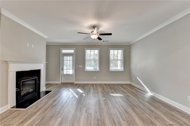 unfurnished living room with ceiling fan, ornamental molding, and light hardwood / wood-style floors