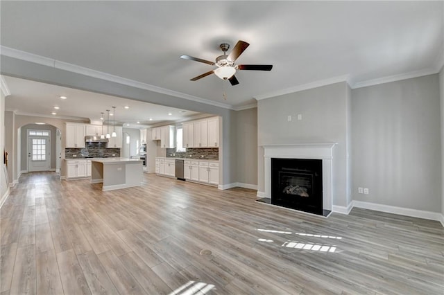 unfurnished living room featuring ornamental molding, light hardwood / wood-style floors, and ceiling fan