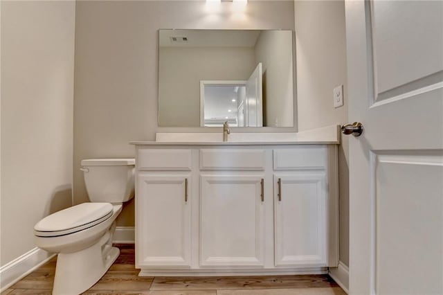 bathroom featuring vanity, hardwood / wood-style floors, and toilet