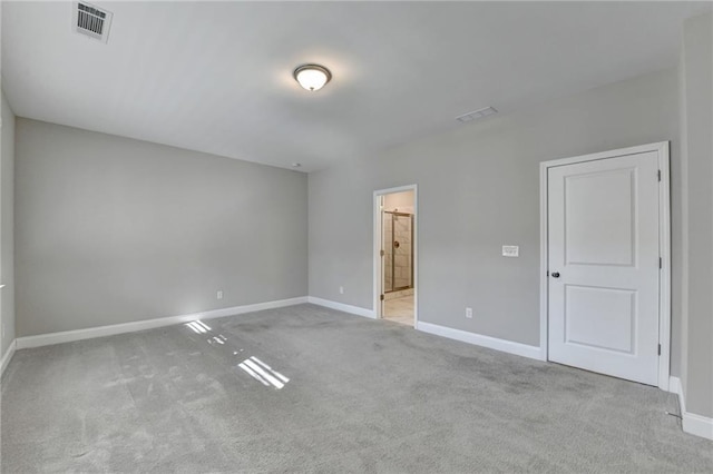 unfurnished bedroom with light carpet and connected bathroom