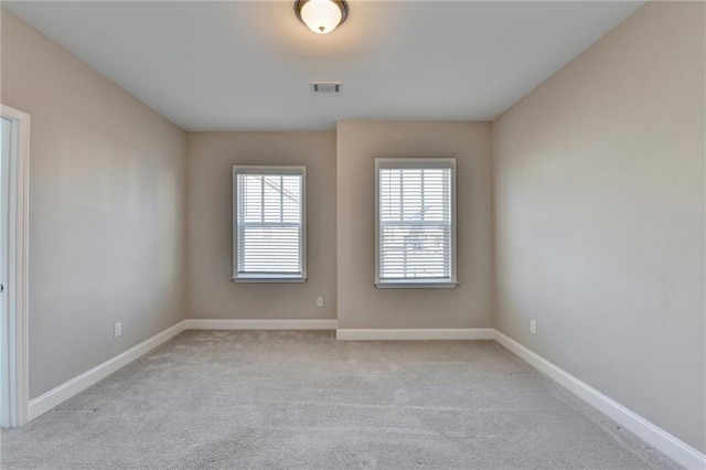 unfurnished room featuring light carpet