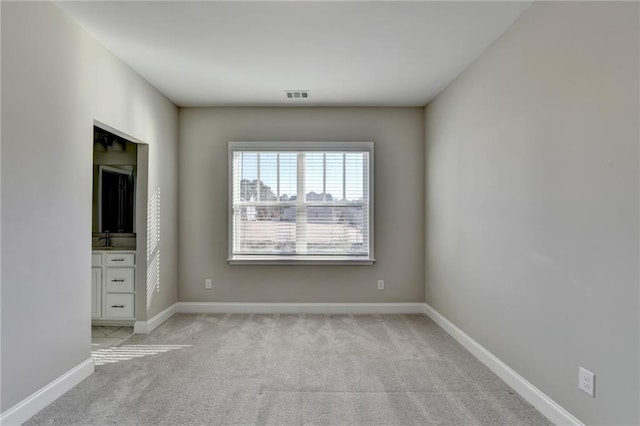 unfurnished room featuring sink and light colored carpet