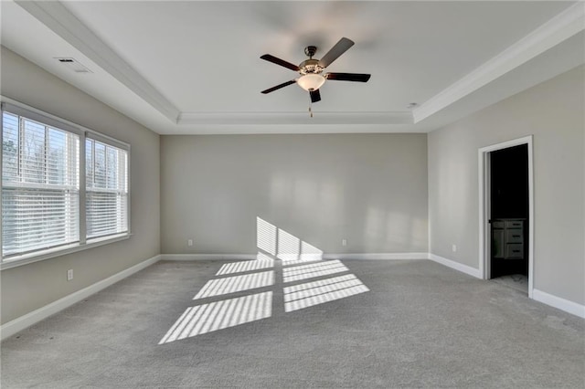 carpeted empty room featuring a tray ceiling and ceiling fan