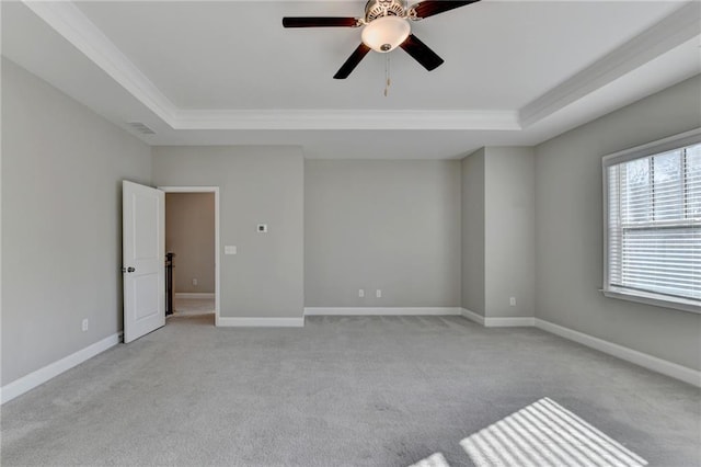 empty room featuring crown molding, light carpet, ceiling fan, and a tray ceiling