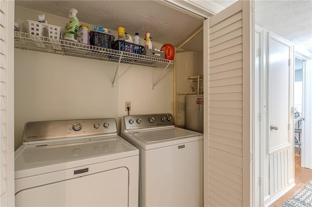 3135 Seven Pines Ct Unit 201, Atlanta, GA 30339 - laundry area featuring electric water heater, independent washer and dryer, and a textured ceiling
