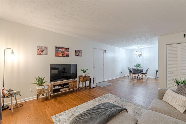 3135 Seven Pines Ct Unit 201, Atlanta, GA 30339 - living room with wood finished floors, a textured ceiling, and a chandelier