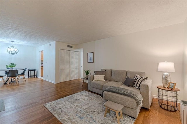 3135 Seven Pines Ct Unit 201, Atlanta, GA 30339 - living area featuring a chandelier, wood finished floors, and a textured ceiling