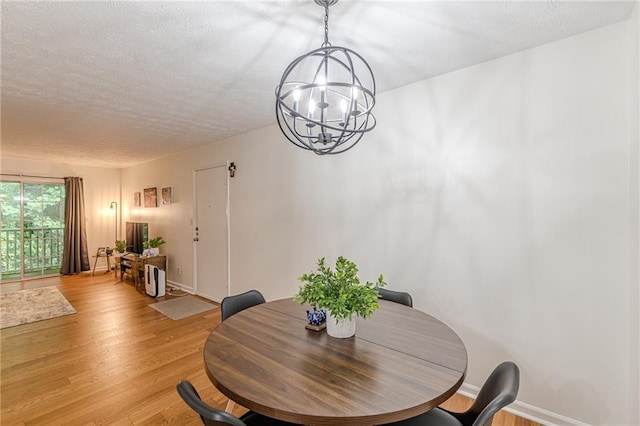 3135 Seven Pines Ct Unit 201, Atlanta, GA 30339 - dining room featuring a chandelier, light wood finished floors, and a textured ceiling