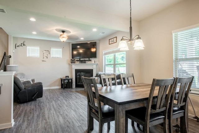 dining space with hardwood / wood-style floors and an inviting chandelier