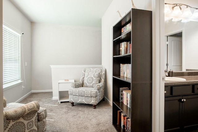 living area featuring sink and light carpet