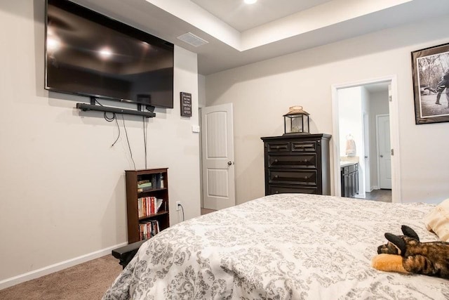 bedroom featuring ensuite bathroom and carpet flooring