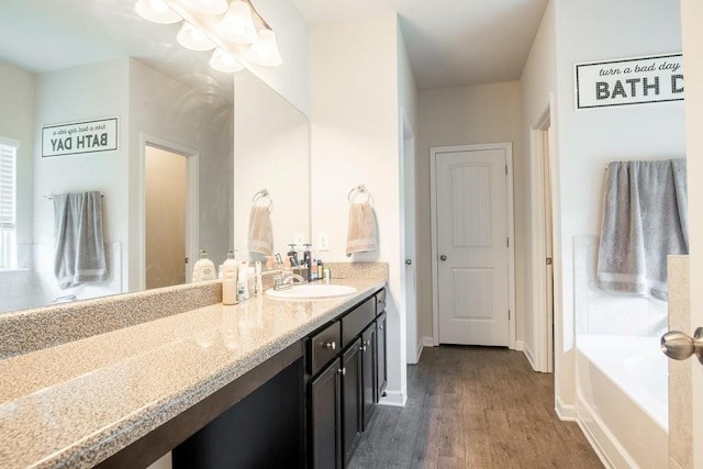 bathroom with hardwood / wood-style floors, vanity, and a bathtub