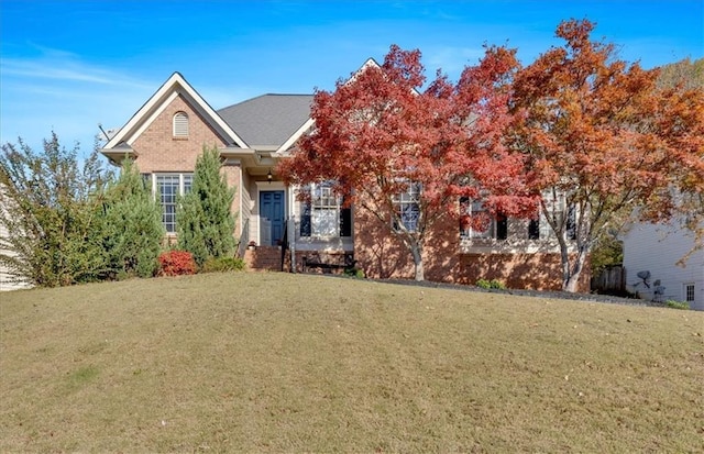 view of front facade with brick siding and a front lawn